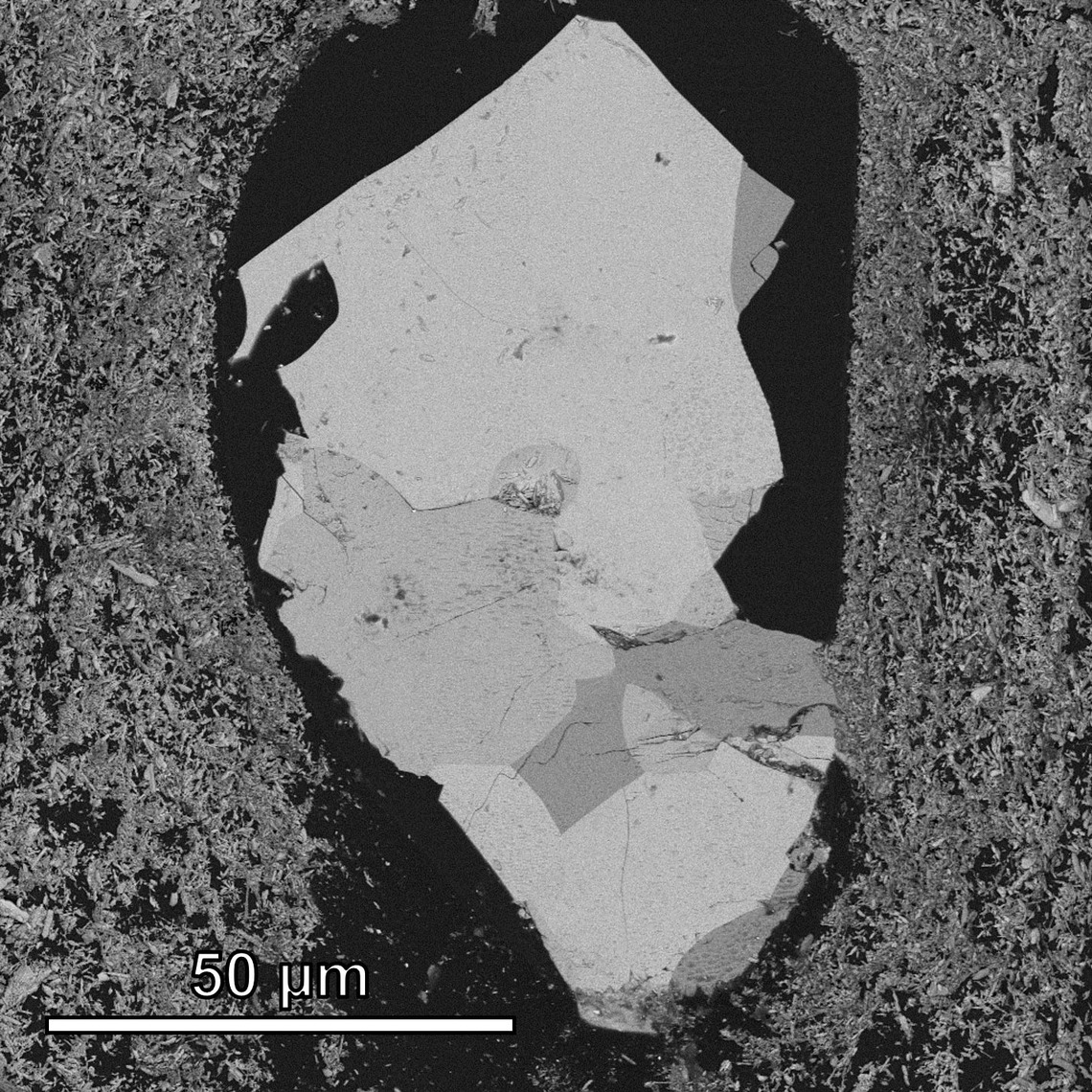 Researchers used a diamond knife to slice through the epoxy and expose a section through the inside of the dust particle, seen here under an electron microscope.