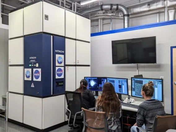 Students use the transmission electron microscope, or TEM, to study a meteorite sample at the KMICF